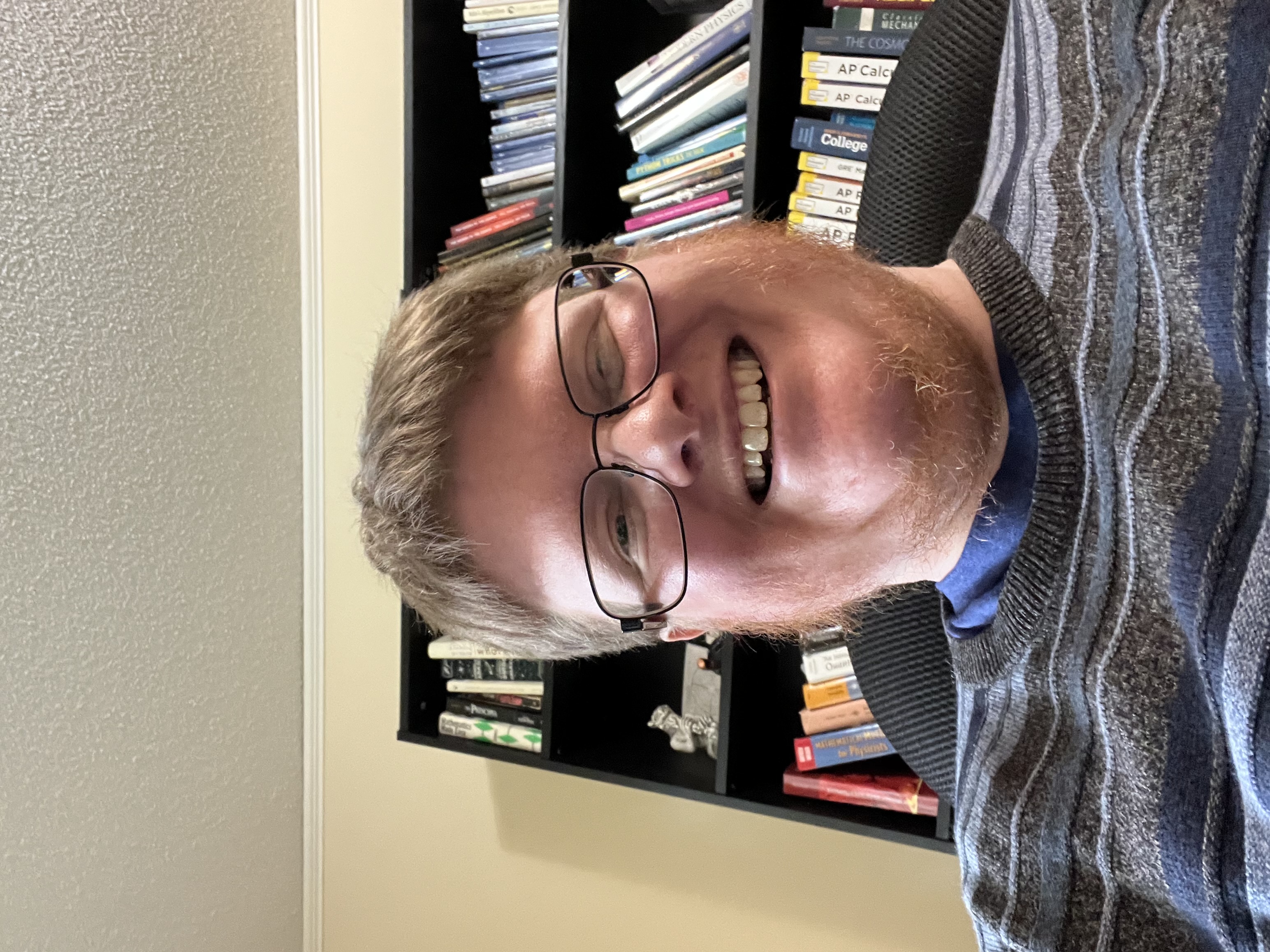 Bookshelves in office where I teach at home, blue striped sweater.